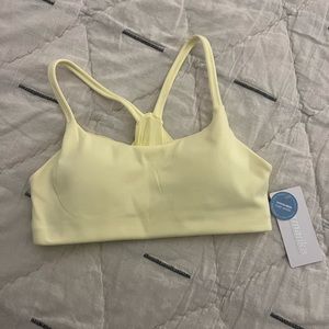 Small, yellow sports bra with tags intact